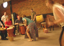 Left to right: Steve Kellar (hands), Toni Kellar and Andy Hall (sitting), and Matt Smith and Andy McVey (standing) drum for Molly Watson and dancers